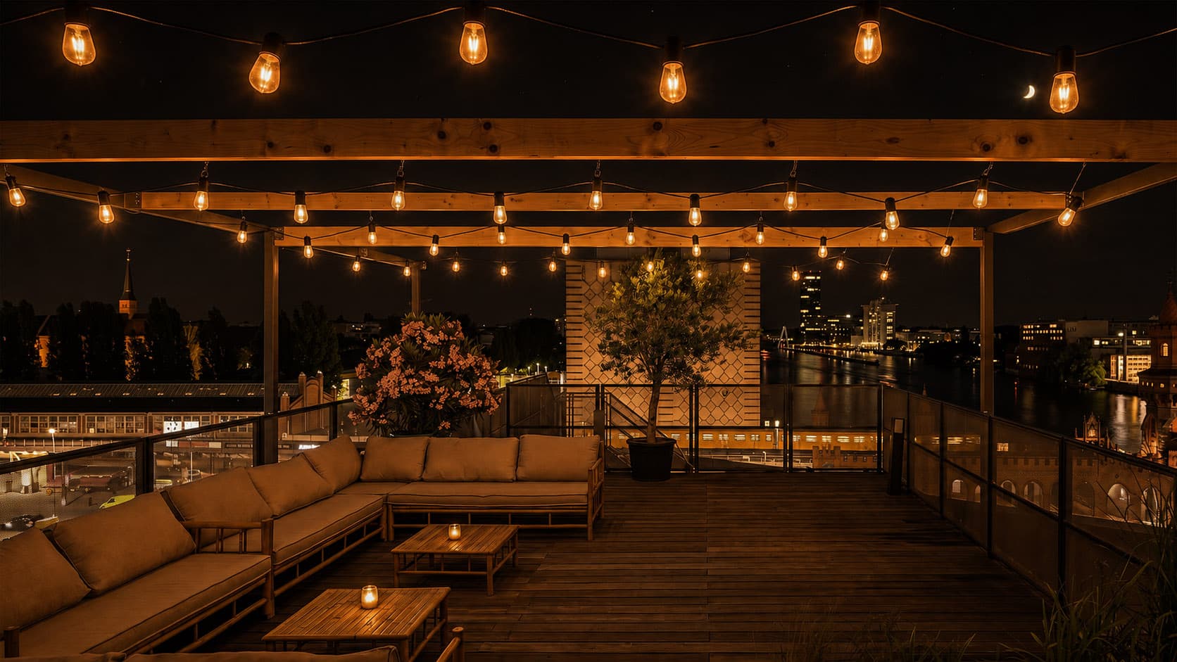 Lounge-Terrasse bei Nacht mit Lichterketten und Skyline