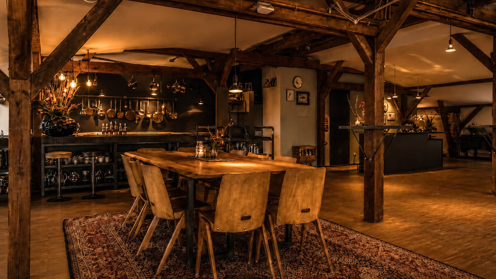 Lange Holztafel vor offener Küche im Loft